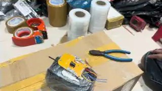 Hand near tape rolls and packing supplies