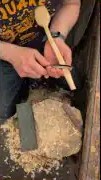 Hand guiding chisel into wood carving