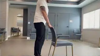 Person rising from chair using armrests