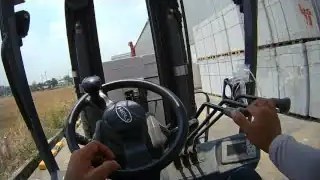 Hands on forklift controls and steering wheel