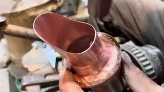 Hands holding copper pipe cutter tool